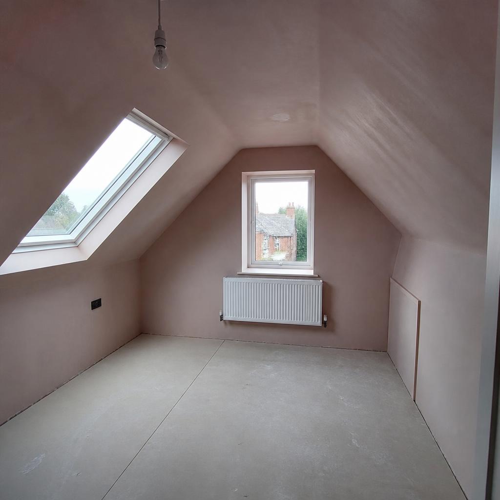Loft conversion freshly plastered with sloped ceilings
