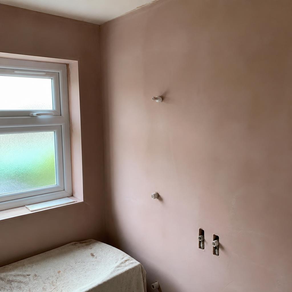 Freshly plastered bathroom wall ready for tiling