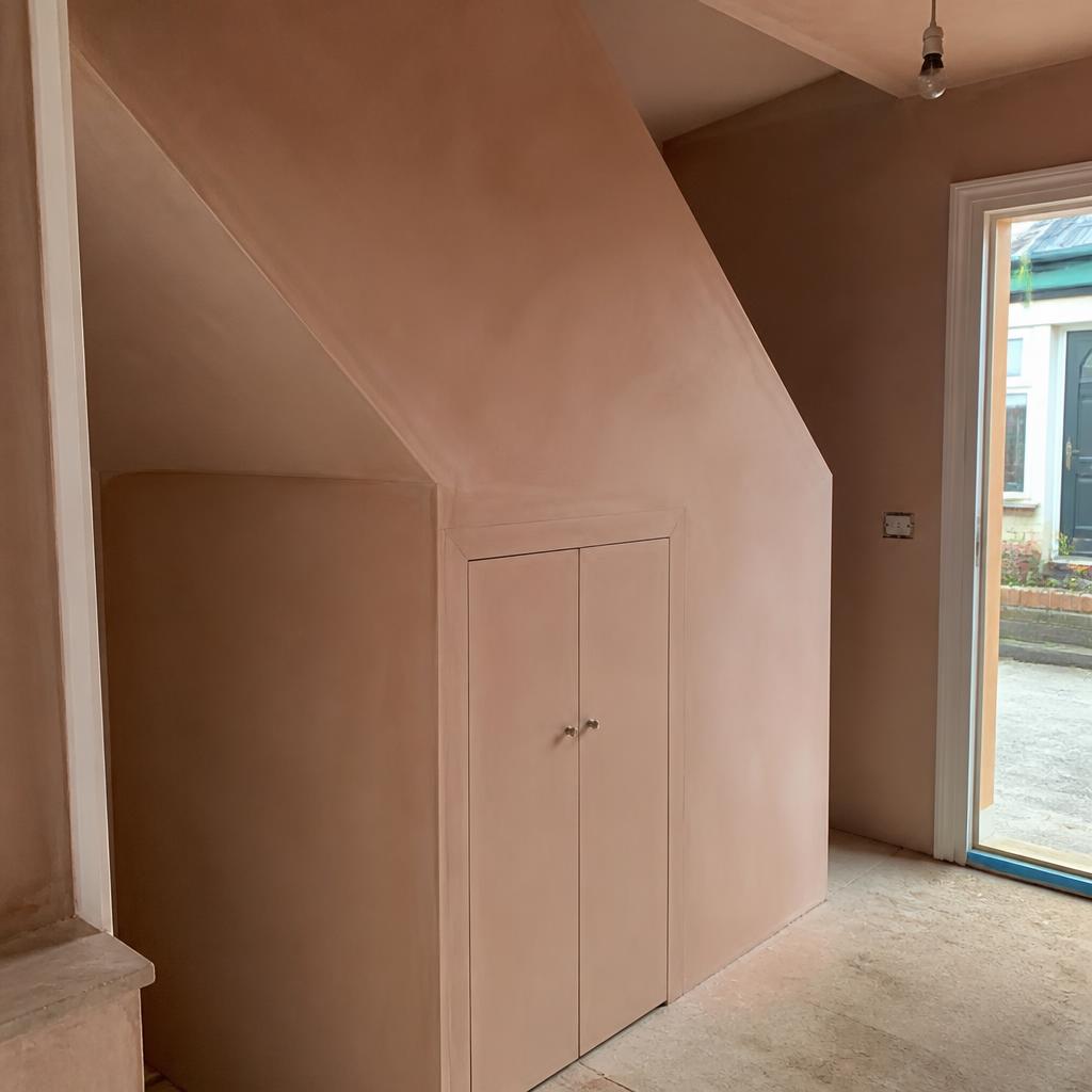 Plastered understairs cupboard with smooth pink finish