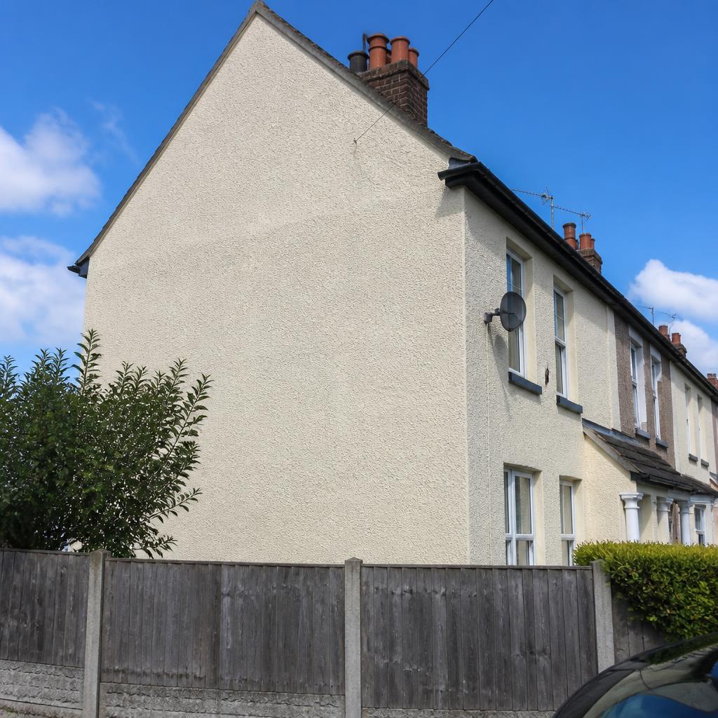 Cream textured render on a UK end-terrace side wall