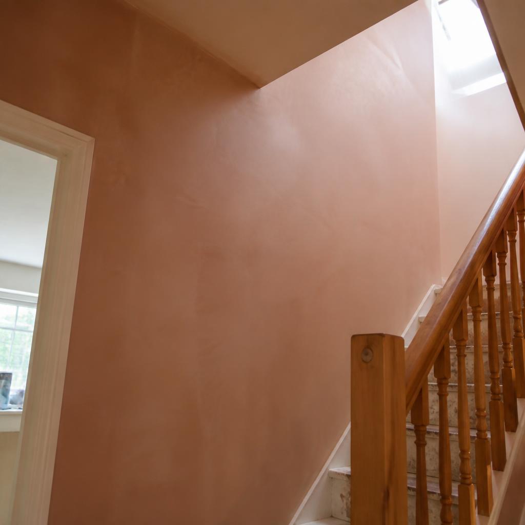 Plastered staircase wall with smooth pink finish